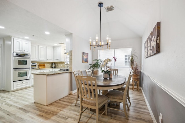 dining space featuring a notable chandelier, baseboards, visible vents, and light wood-style floors