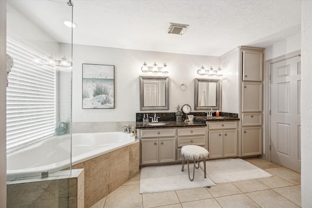 full bathroom featuring a bath, tile patterned floors, visible vents, and double vanity