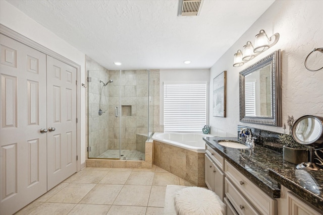 bathroom featuring tile patterned flooring, visible vents, vanity, a bath, and a stall shower