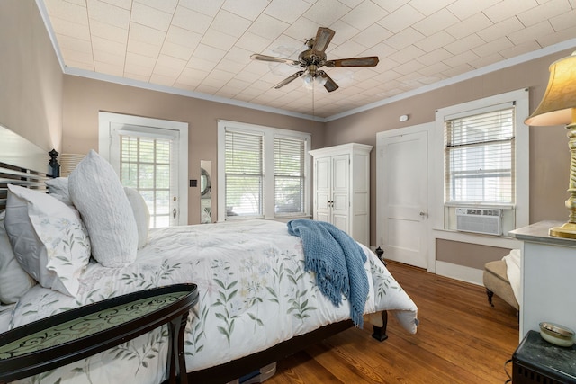 bedroom with wood finished floors, a ceiling fan, cooling unit, and ornamental molding