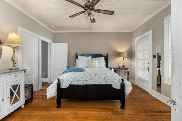 bedroom featuring ceiling fan, ornamental molding, and wood finished floors