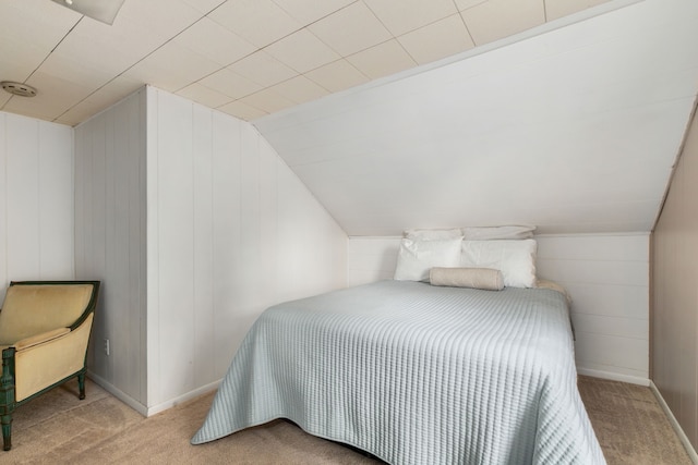 bedroom featuring baseboards, carpet flooring, and vaulted ceiling