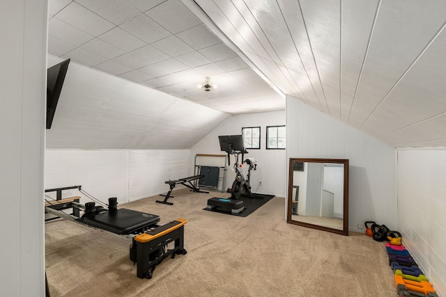 exercise area featuring vaulted ceiling and carpet flooring