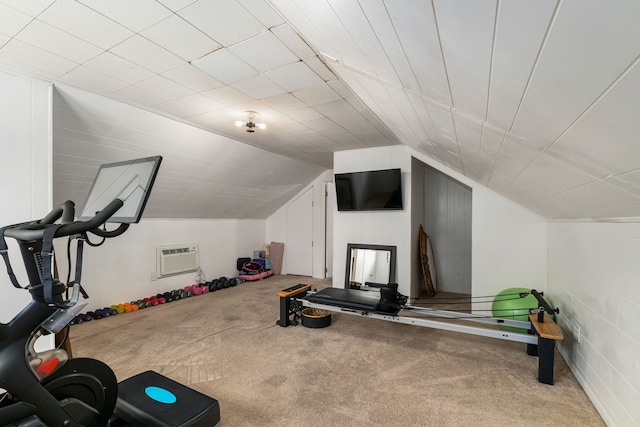 workout area featuring vaulted ceiling, an AC wall unit, and carpet