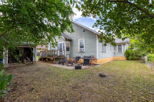 rear view of house featuring a wooden deck, fence, a yard, and a patio