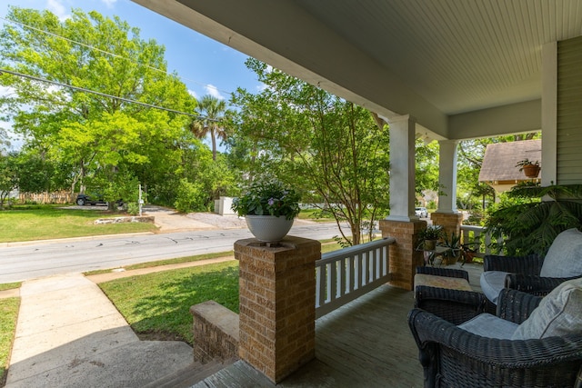 deck with a yard and covered porch