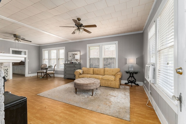 living room with wood finished floors, a ceiling fan, and ornamental molding