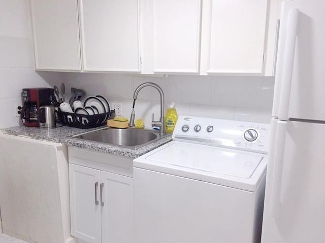 clothes washing area with a sink, laundry area, and washer / clothes dryer