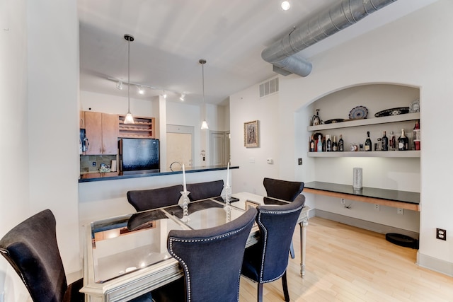 dining room with rail lighting, light wood-style floors, and visible vents