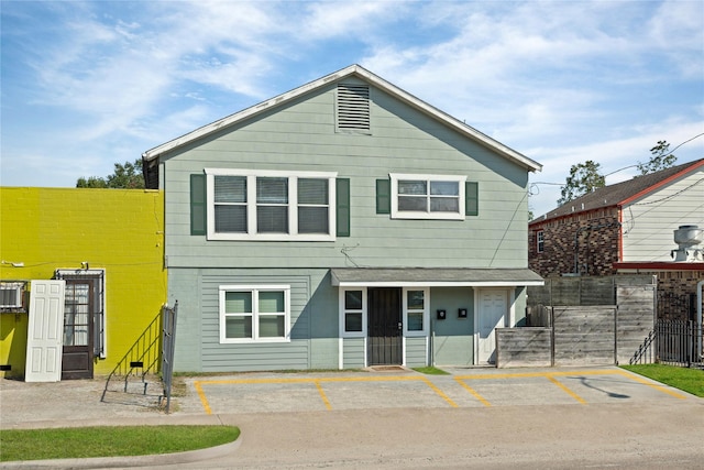 view of front of property featuring uncovered parking and fence