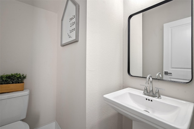half bath featuring a sink and toilet