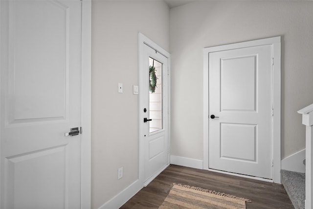 foyer featuring dark wood-style flooring and baseboards