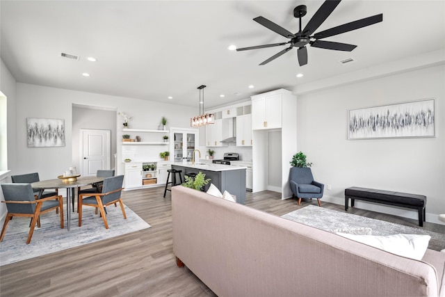 living area featuring ceiling fan, recessed lighting, wood finished floors, and baseboards
