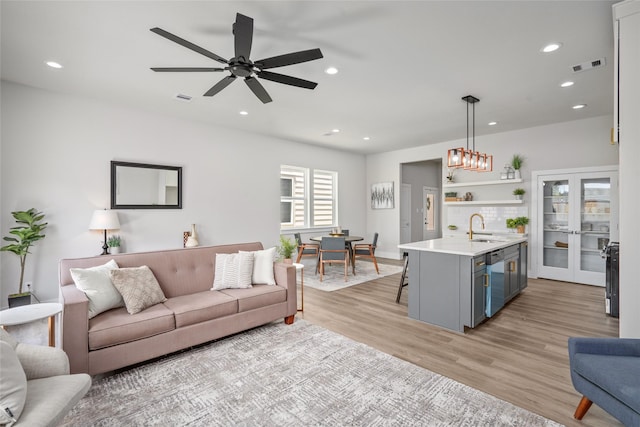 living area featuring recessed lighting, light wood-style flooring, and a ceiling fan