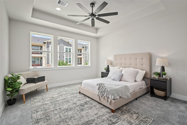 carpeted bedroom featuring a tray ceiling, baseboards, a ceiling fan, and recessed lighting