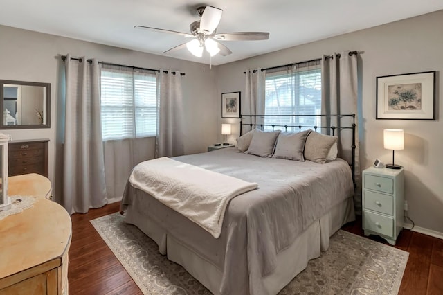 bedroom featuring baseboards, a ceiling fan, and dark wood-style floors