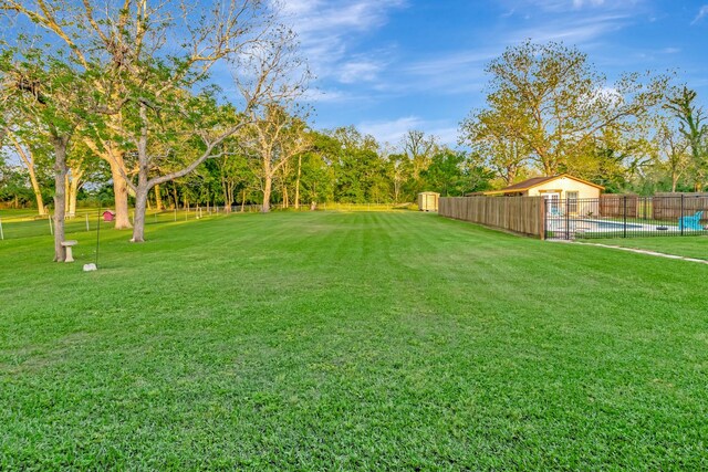 view of yard featuring fence and a fenced in pool