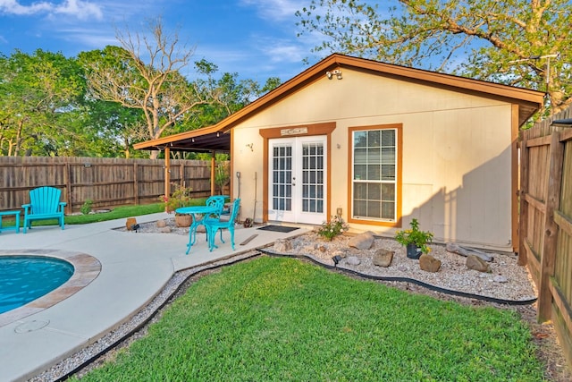 back of property featuring a lawn, a fenced backyard, french doors, and a patio