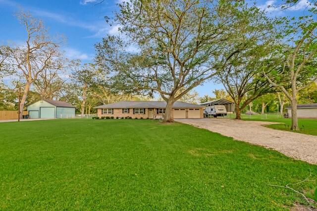ranch-style home with a front lawn, fence, a detached garage, and dirt driveway