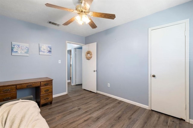 bedroom featuring baseboards, wood finished floors, visible vents, and a ceiling fan