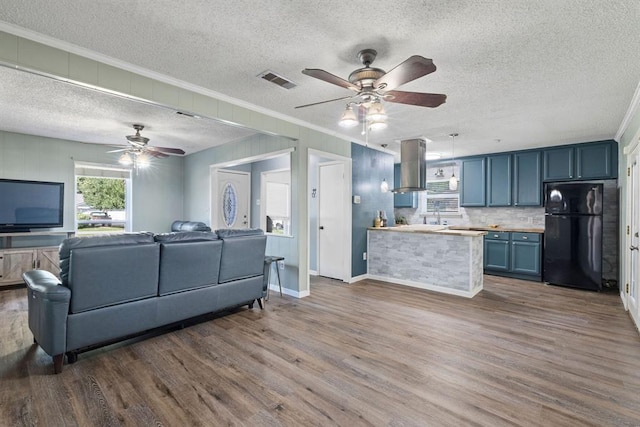 living room featuring a textured ceiling, ceiling fan, dark wood-style flooring, and ornamental molding