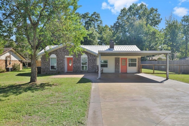 ranch-style home with a standing seam roof, driveway, metal roof, fence, and a front yard