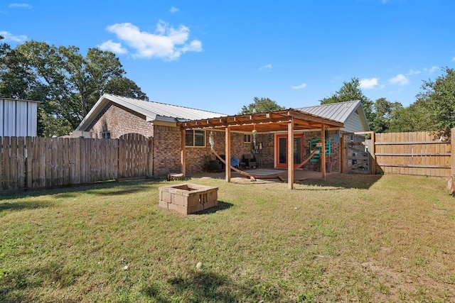rear view of property featuring a fenced backyard, brick siding, a gate, and metal roof