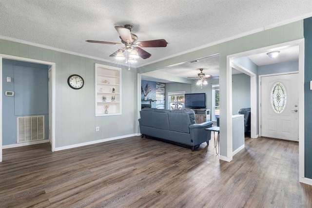 living area featuring ornamental molding, visible vents, a wealth of natural light, and ceiling fan