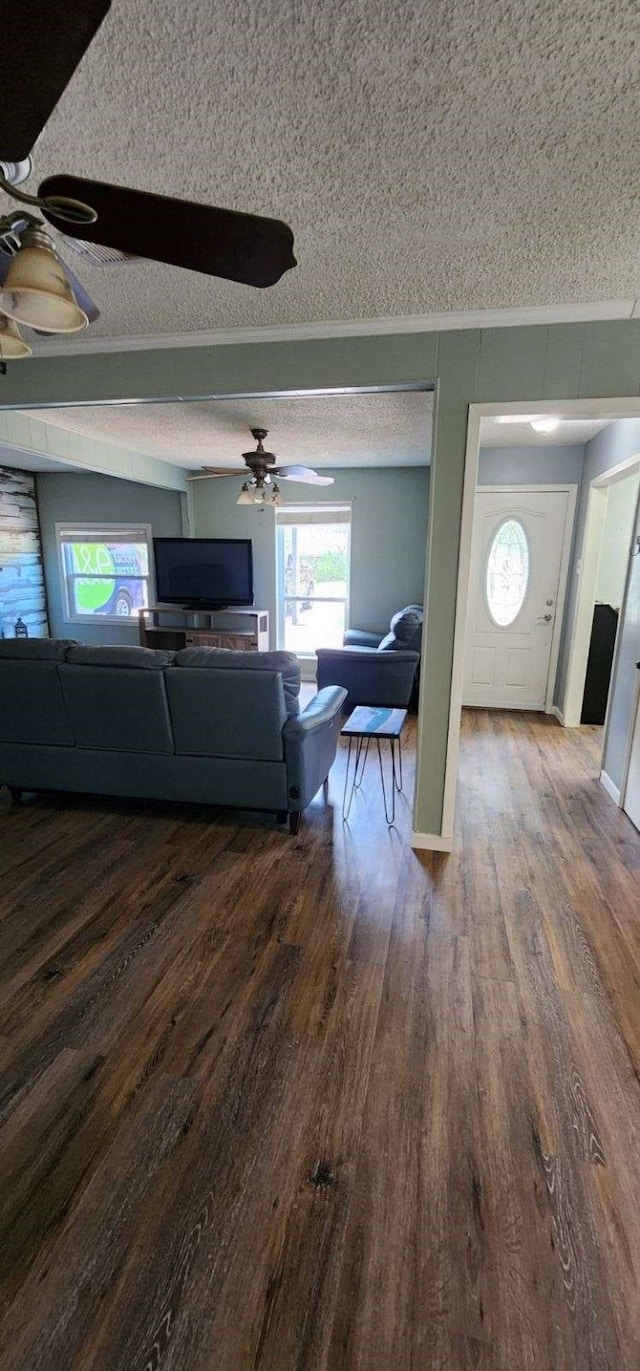 living room with baseboards, a textured ceiling, ceiling fan, and dark wood-style flooring