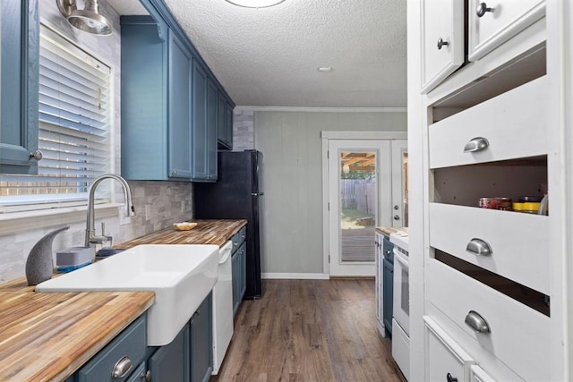 kitchen featuring dark wood finished floors, butcher block countertops, blue cabinetry, and tasteful backsplash