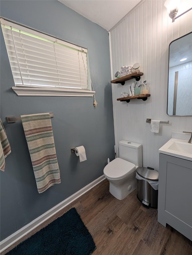 bathroom with wood finished floors, vanity, and toilet