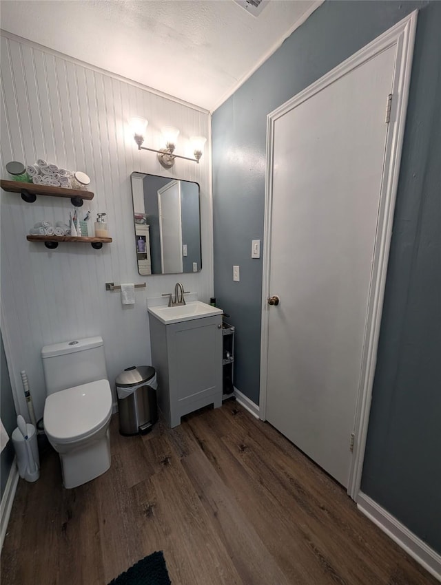 bathroom with wood finished floors, vanity, and toilet