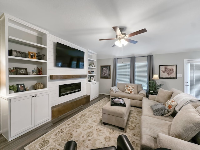 2222 E Winding Pines Dr, Tomball, TX 77375 - living room with dark wood-style flooring, baseboards, a fireplace, built in features, and ceiling fan