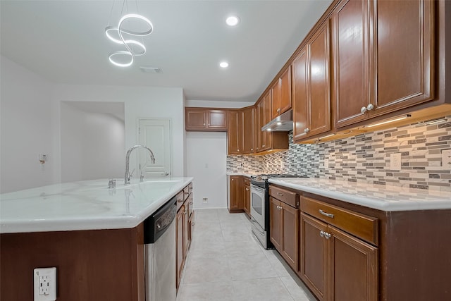 24543 Carlton Springs Ln, Katy, TX 77494 - kitchen with stainless steel appliances, under cabinet range hood, a sink, backsplash, and brown cabinets