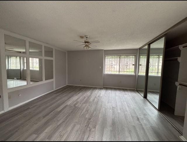 2332 Woodland Park Dr Unit 11, Houston, TX 77077 - unfurnished bedroom featuring a textured ceiling, wood finished floors, baseboards, and a ceiling fan