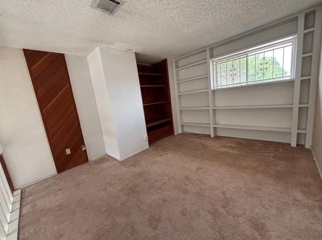 2332 Woodland Park Dr Unit 11, Houston, TX 77077 - unfurnished bedroom with a textured ceiling, carpet flooring, and wood walls