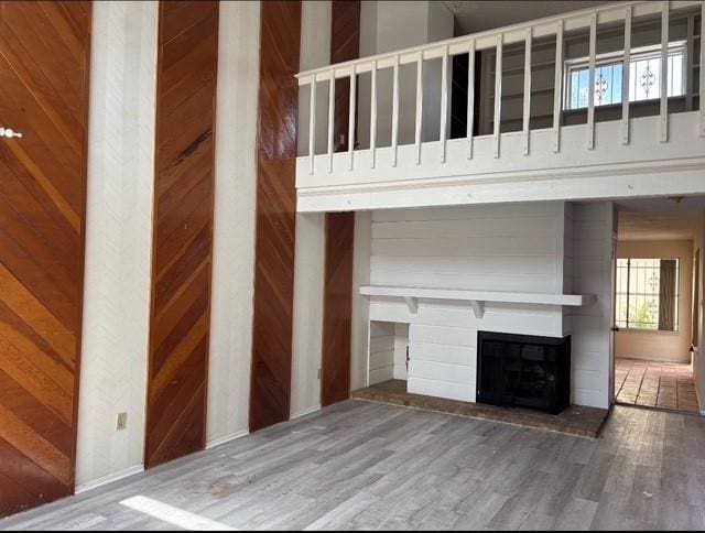 2332 Woodland Park Dr Unit 11, Houston, TX 77077 - unfurnished living room with a fireplace with raised hearth, wood finished floors, and wood walls
