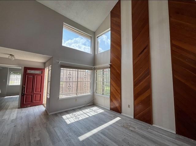 2332 Woodland Park Dr Unit 11, Houston, TX 77077 - foyer featuring wood finished floors, high vaulted ceiling, and baseboards