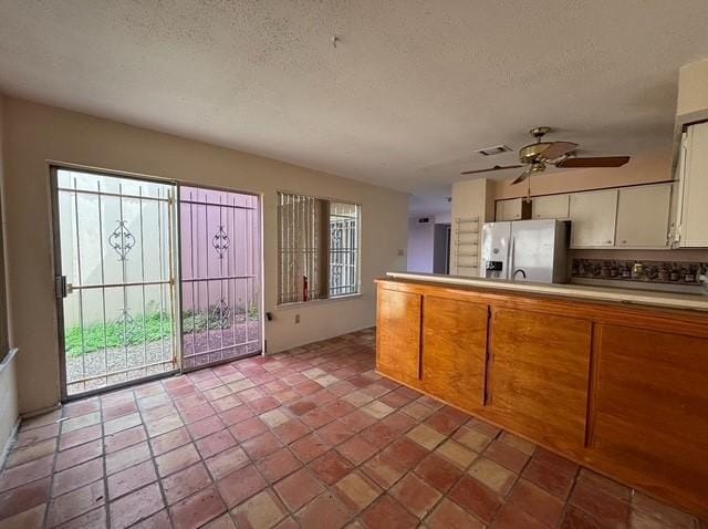 2332 Woodland Park Dr Unit 11, Houston, TX 77077 - kitchen featuring stainless steel fridge with ice dispenser, healthy amount of natural light, a textured ceiling, a ceiling fan, and white cabinetry