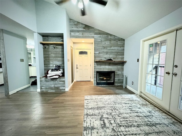 unfurnished living room with baseboards, a ceiling fan, wood finished floors, and a fireplace