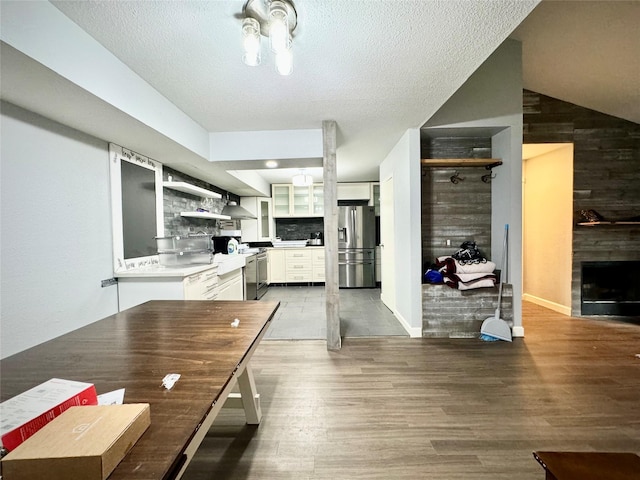 dining space featuring wood finished floors, a textured ceiling, and a fireplace