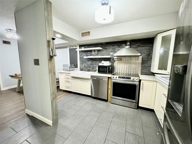 kitchen featuring stainless steel appliances, a sink, visible vents, decorative backsplash, and light countertops