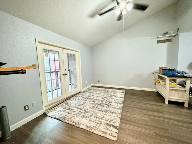 doorway with lofted ceiling, a textured wall, wood finished floors, a ceiling fan, and french doors