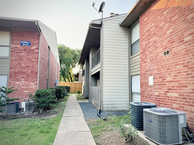 view of side of home featuring central AC and fence