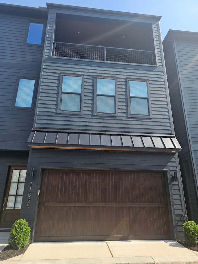 view of front of property featuring metal roof, a standing seam roof, and a garage