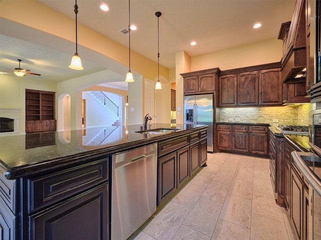 21315 Whistle Wood Dr, Richmond, TX 77406 - kitchen with a sink, ceiling fan, arched walkways, backsplash, and appliances with stainless steel finishes