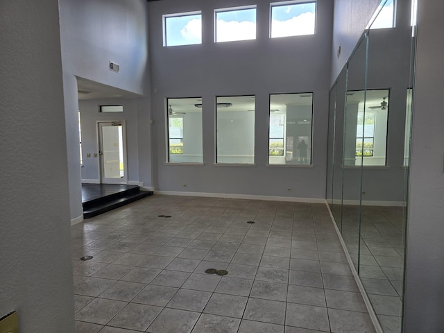 12203 Ashley Circle Dr E, Houston, TX 77071 - unfurnished living room featuring a towering ceiling, baseboards, visible vents, and light tile patterned floors
