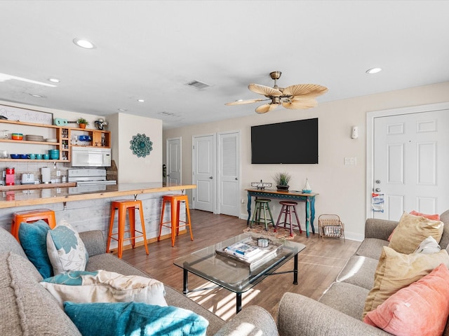 living area featuring recessed lighting, wood finished floors, visible vents, and baseboards