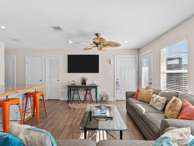 living area featuring recessed lighting, wood finished floors, visible vents, and baseboards