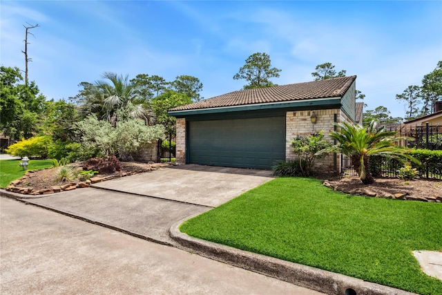 exterior space featuring fence, a front lawn, and a garage